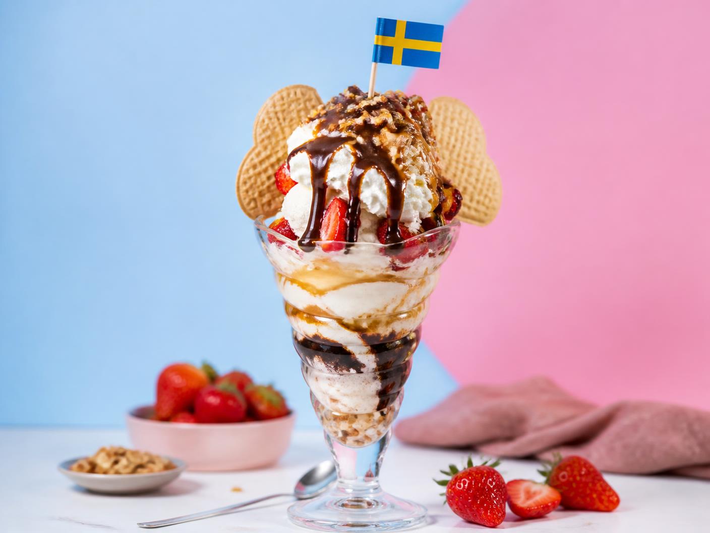 Stor glassdessert med grädde, jordgubbar och svensk flagga